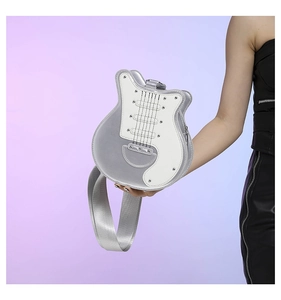 Detailed close-up of a guitar-shaped crossbody bag with metallic silver and white leather
