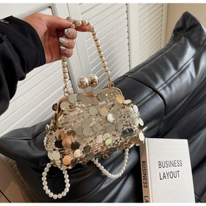Macro shot of luxury evening bag with champagne sequins and elegant pearl handle detail
