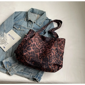 Detailed close-up of large leopard print tote bag with thick strap on white background
