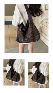 Close-up of leopard print canvas tote bag with brown leather strap detail