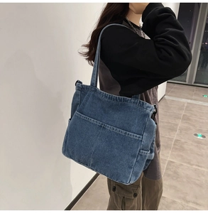 Dettaglio della borsa tote in denim lavato blu con tasche laterali e qualità delle cuciture