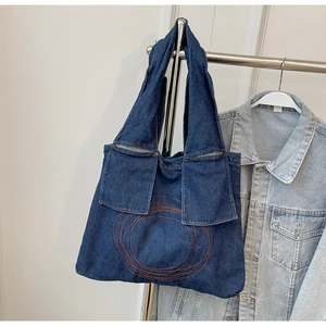 Close-up of classic blue denim tote bag featuring decorative circular stitch embroidery