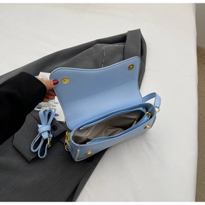 Detail van de lichtblauwe imitatielederen tas met binnenzak en goudkleurige hardware