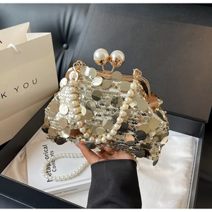 Close-up of golden sequins and pearl closure on a luxury evening clutch bag