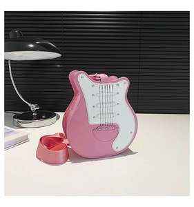 Detail shot of a pink guitar-shaped crossbody bag with decorative stitching and studs