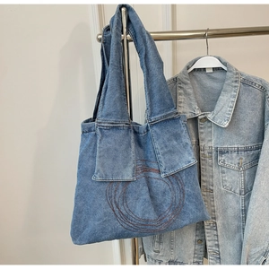 Detailed embroidery of concentric circles and double patch pockets on denim tote bag