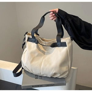 Detail view of large canvas tote bag with contrast nylon handles and side buckle straps