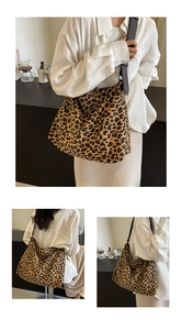 Detail view of large leopard print canvas tote bag with adjustable brown leather strap