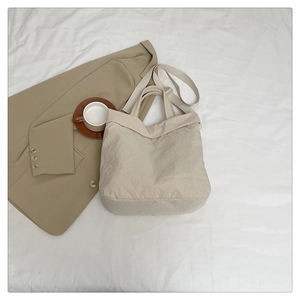 Gros plan détaillé du grand sac cabas beige minimaliste avec texture lisse et bandoulière