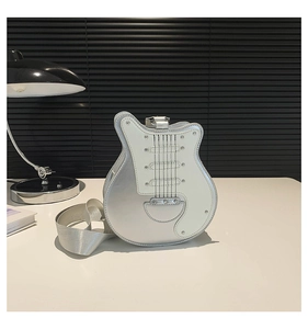 Close-up of a stylish silver guitar-shaped crossbody bag with metallic details
