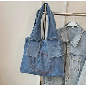 Close-up of large denim tote bag with vintage concentric circle embroidery detail