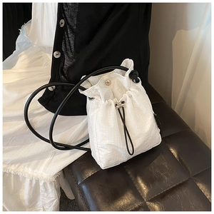 Close-up of white drawstring nylon bucket bag with micro-check texture and silver hardware