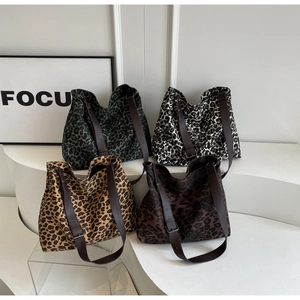 Detailed display of four leopard print canvas tote bags with adjustable brown leather straps