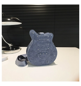 Detail of guitar-shaped crossbody bag featuring blue denim texture and silver metal rivets