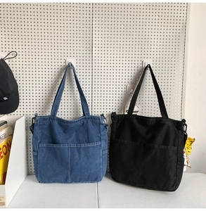 Dettaglio di borse tote in denim blu e tela nera con pratiche doppie tasche frontali