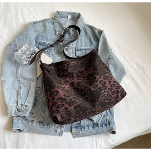 Detail of adjustable leather strap and leopard print canvas texture on large tote bag