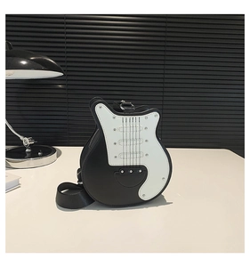 Detail view of guitar shaped crossbody bag with black and white leather finish and wide strap