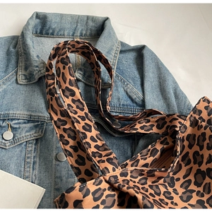 Close-up of leopard print tote bag fabric with zipper closure and canvas shoulder strap