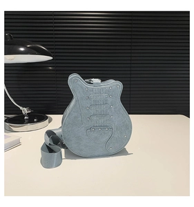 Close-up of light blue guitar-shaped bag with silver rivets and wide textile strap