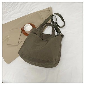 Gros plan d'un cabas en nylon vert olive avec bandoulière réglable et tissu durable