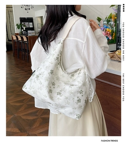 Détail du sac cabas floral avec bordure en dentelle et large bandoulière sur mannequin