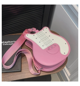 Detail of creative guitar-shaped shoulder bag in pink and beige leather with silver studs