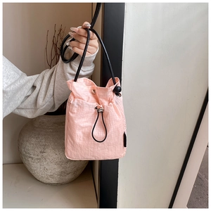 Macro detail of pink waterproof nylon mini bag with drawstring and metal buckle closure