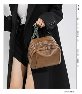 Detailansicht braune Vintage-Tasche mit dreifachem Reißverschluss und Ethno-Gurt