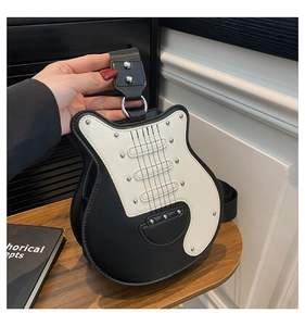 Detailed close-up of a guitar-shaped shoulder bag featuring chic black and white contrast