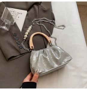 Détail du sac seau plissé argenté avec poignée en bois et chaîne de perles