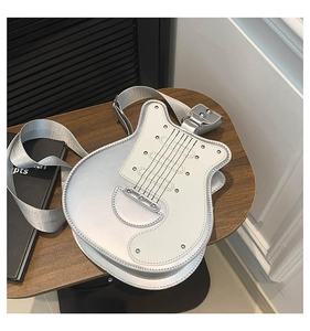 Detail of guitar shaped shoulder bag with silver metallic finish and rivet accents