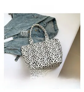 Detailed top-down view of leopard print canvas tote bag with classic animal pattern handles