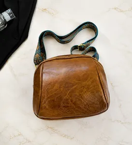 Detailansicht der braunen Vintage PU-Leder Umhängetasche mit gemustertem Schultergurt