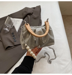 Détail du sac seau plissé argenté avec poignée en bois et bandoulière en perles