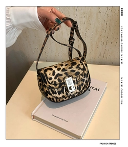 Close-up of leopard print handbag featuring a silver metal buckle and horsehair texture
