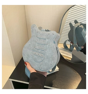 Detailed view of light blue guitar shaped shoulder bag with silver rivets and wide strap