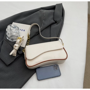 Detail van de crèmekleurige tas met gouden ketting en smartphone voor de maatreferentie