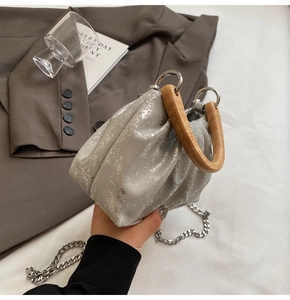 Détail du sac seau plissé argenté avec texture métallique et poignée en bois vintage