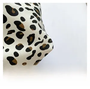 Macro detail of twill fabric with leopard print texture on a casual fashion handbag