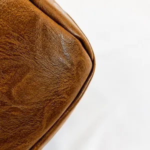 Detailaufnahme von karamellbraunem Kunstleder mit feiner Naht und natürlicher Textur