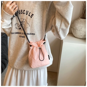 Detailed view of pink drawstring nylon crossbody bag with micro-wrinkle texture