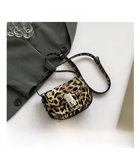 Close-up of leopard print saddle bag with plush texture and vintage gold metal clasp