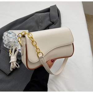 Detail van beige schoudertas met bruine randen, gouden ketting en verstelbare riem