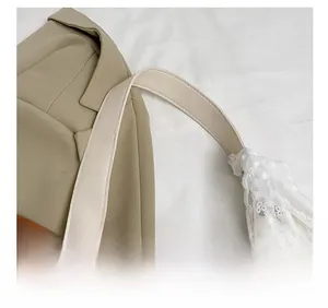 Détail de la bandoulière en cuir blanc et bordure en dentelle sur sac à fleurs