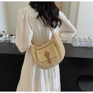 Große beige Strandtasche aus Stroh mit kleiner Vordertasche und Lederriemen im Detail