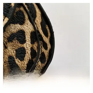 Close-up of leopard print fabric texture with high-quality black rounded piping and stitching