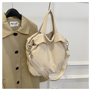 Détail du sac cabas en nylon beige avec bandoulière réglable et ferrures en argent poli