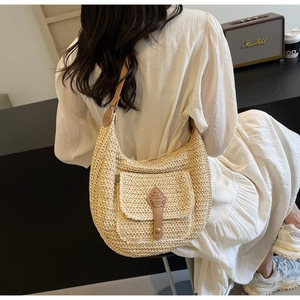 Detailansicht der beigen Strohtasche mit brauner Ledertasche und Riemendetails