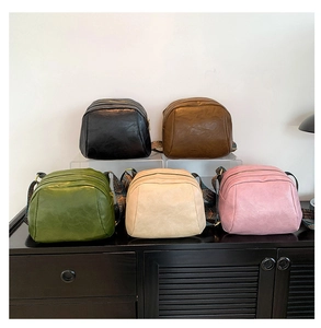 Detailansicht von fünf PU-Muscheltaschen in verschiedenen Farben mit Ethno-Gurten
