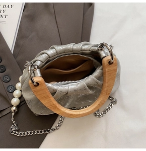 Gros plan du sac seau plissé argenté avec poignée en bois et bandoulière en perles